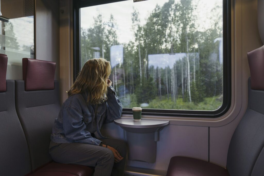 Woman traveling by train looking out of window